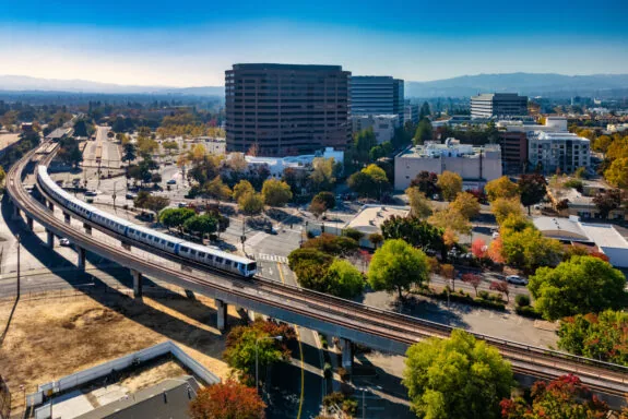 Downtown Concord skyline during autumn, with a BART Train and tracks in the foreground, and Diablo Range mountains in the background. Concord, California is part of the San Francisco Bay Area and a suburb of San Francisco.