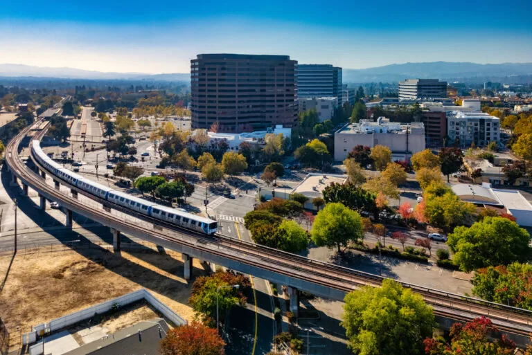 Downtown Concord skyline during autumn, with a BART Train and tracks in the foreground, and Diablo Range mountains in the background. Concord, California is part of the San Francisco Bay Area and a suburb of San Francisco.