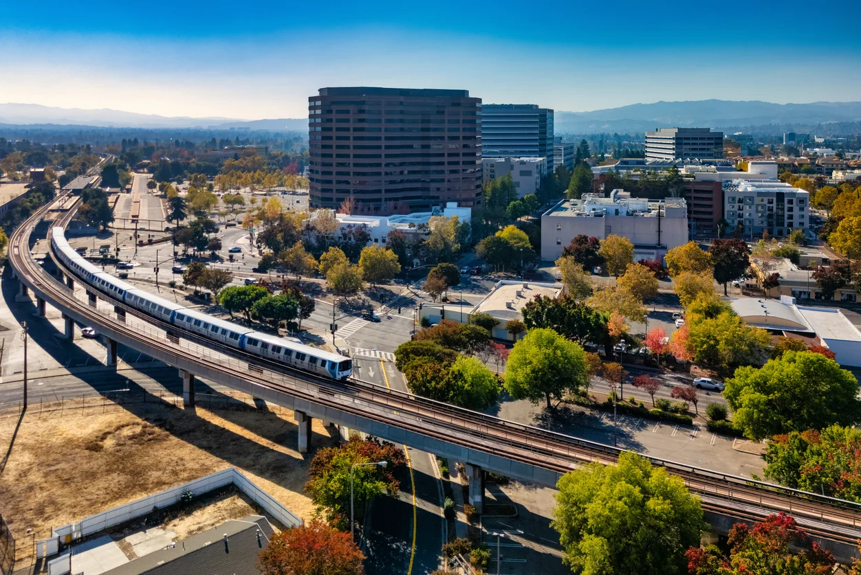 Downtown Concord skyline during autumn, with a BART Train and tracks in the foreground, and Diablo Range mountains in the background. Concord, California is part of the San Francisco Bay Area and a suburb of San Francisco.