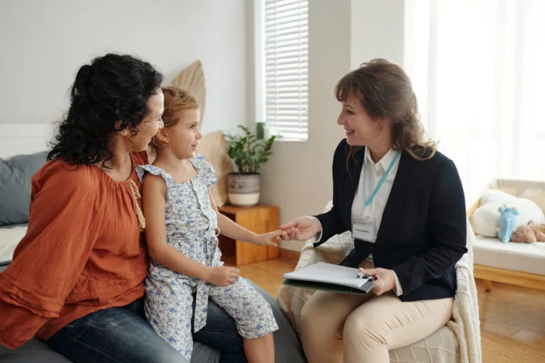 Social worker talking to little girl and her mom during her visit