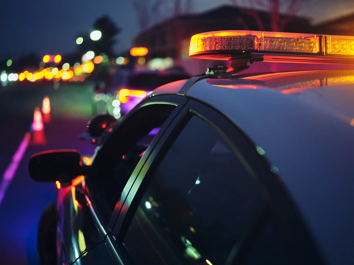 A police car stopping a vehicle at night.
